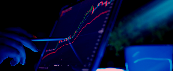 A person analyzing a forex stock chart on a laptop, focused on financial data and market trends.